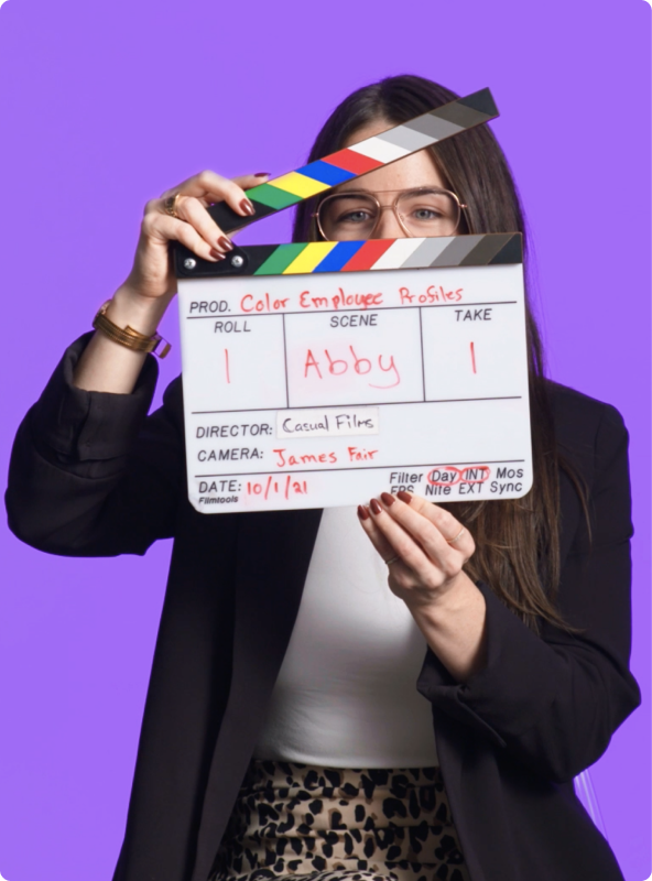 Woman holding a slateboard in front of her face before filming a video