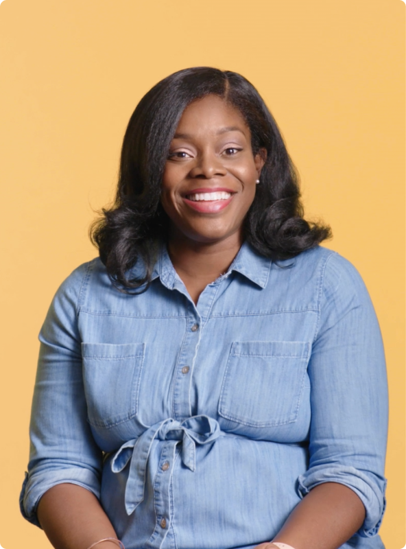 Woman sitting down wearing a blue shirt smiling at the camera