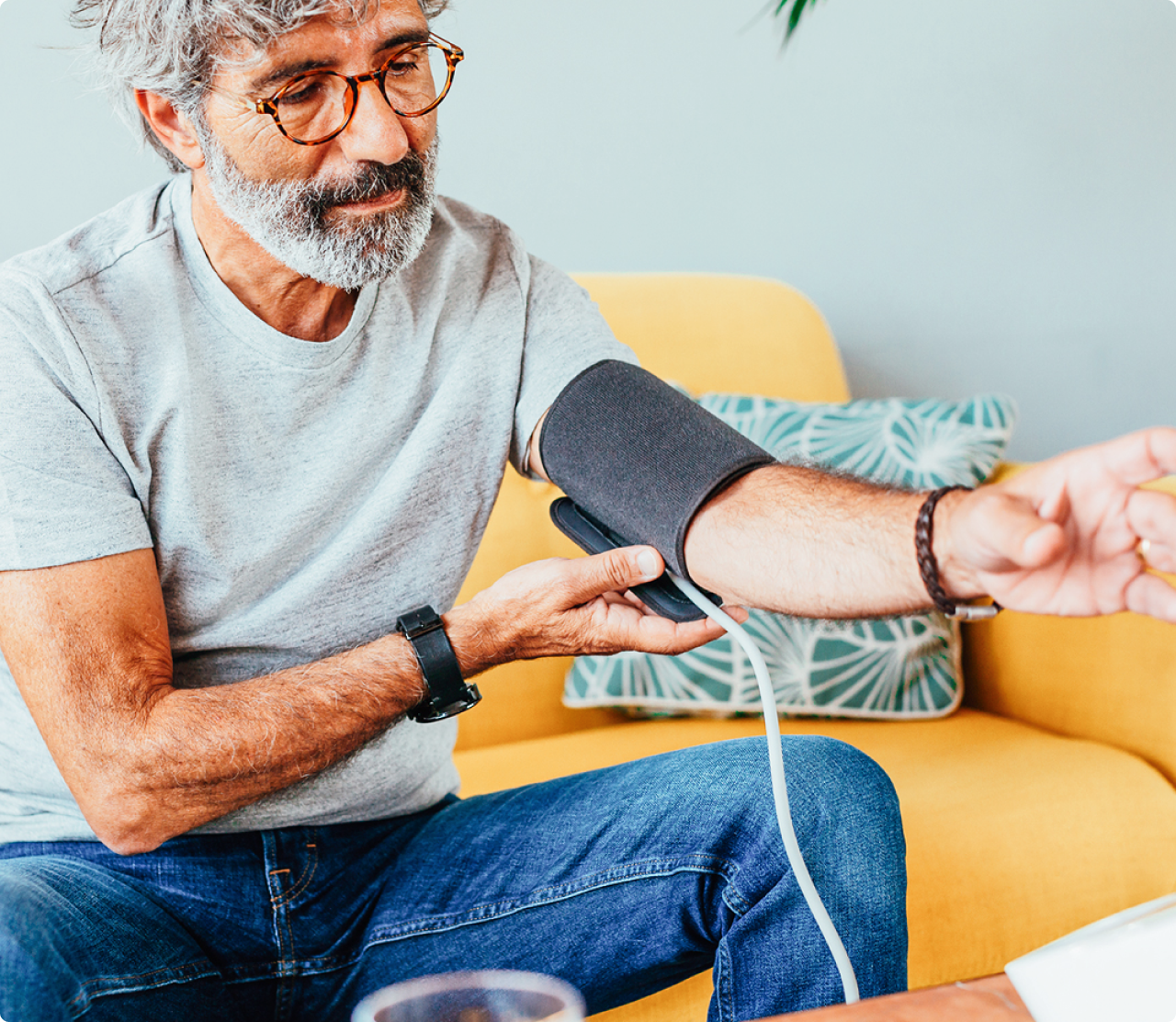 Man sitting down checking his blood pressure