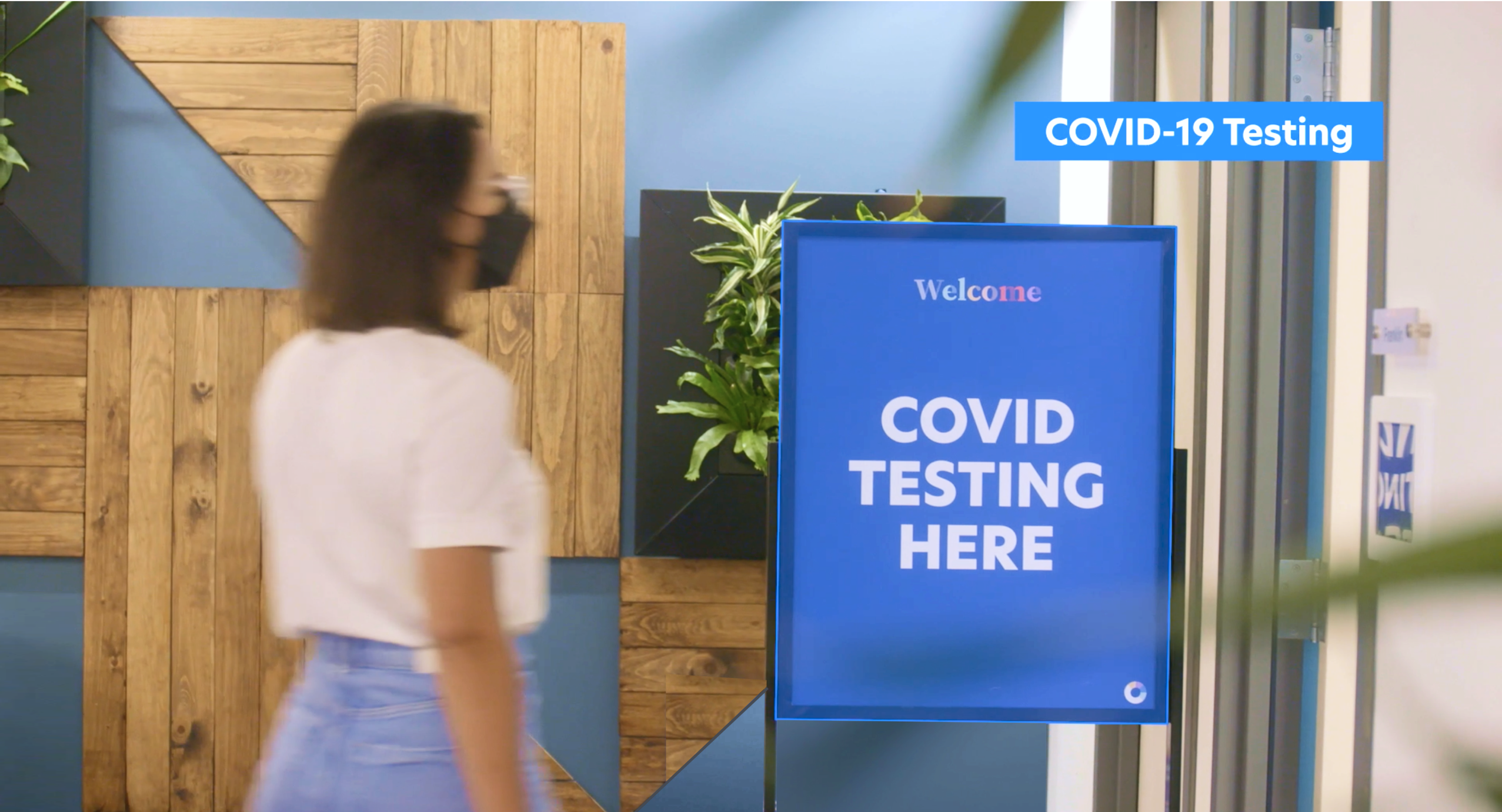 Woman wearing a mask walking into a Color COVID-19 testing location