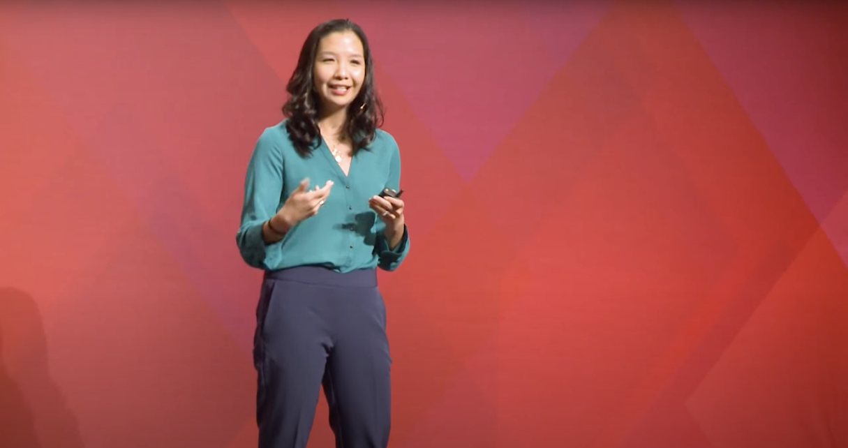 Alicia Zhou standing in front of audience giving a TEDx talk