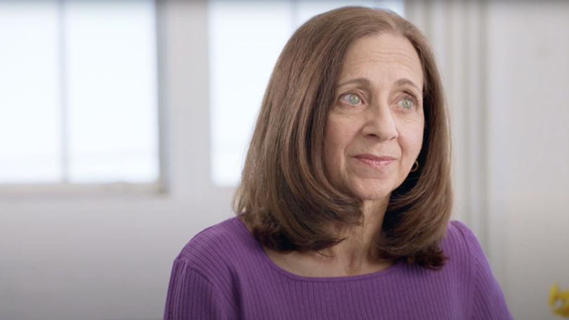 Woman wearing purple shirt staring off to the side