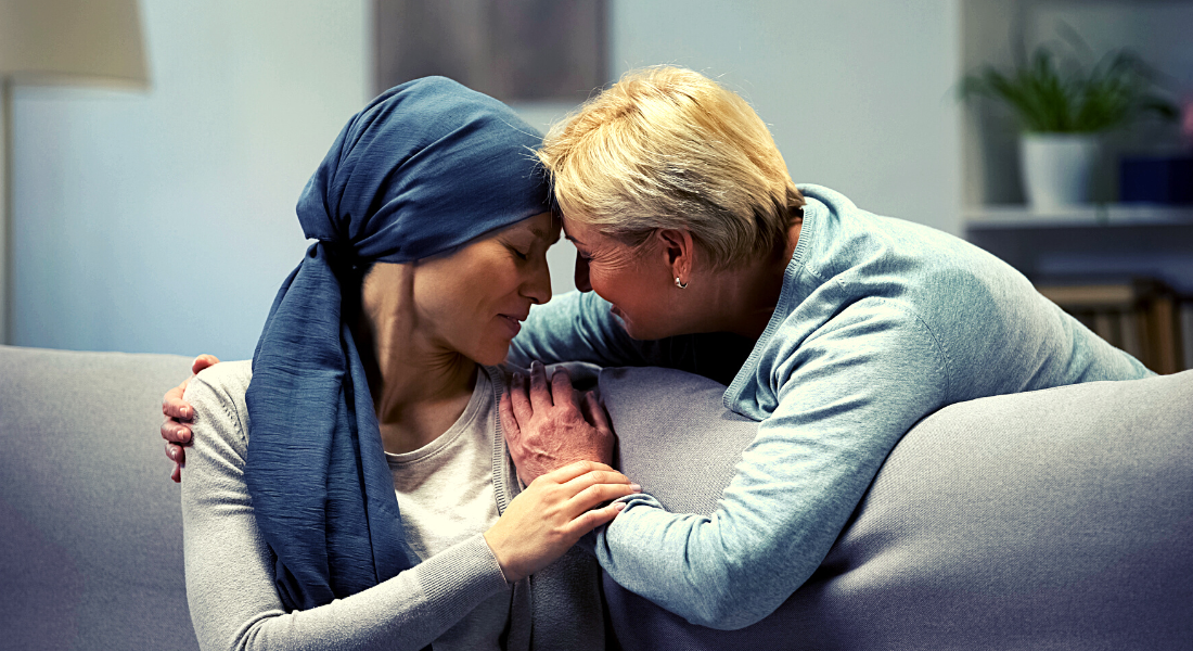 A woman comforting another woman who is going through cancer treatment